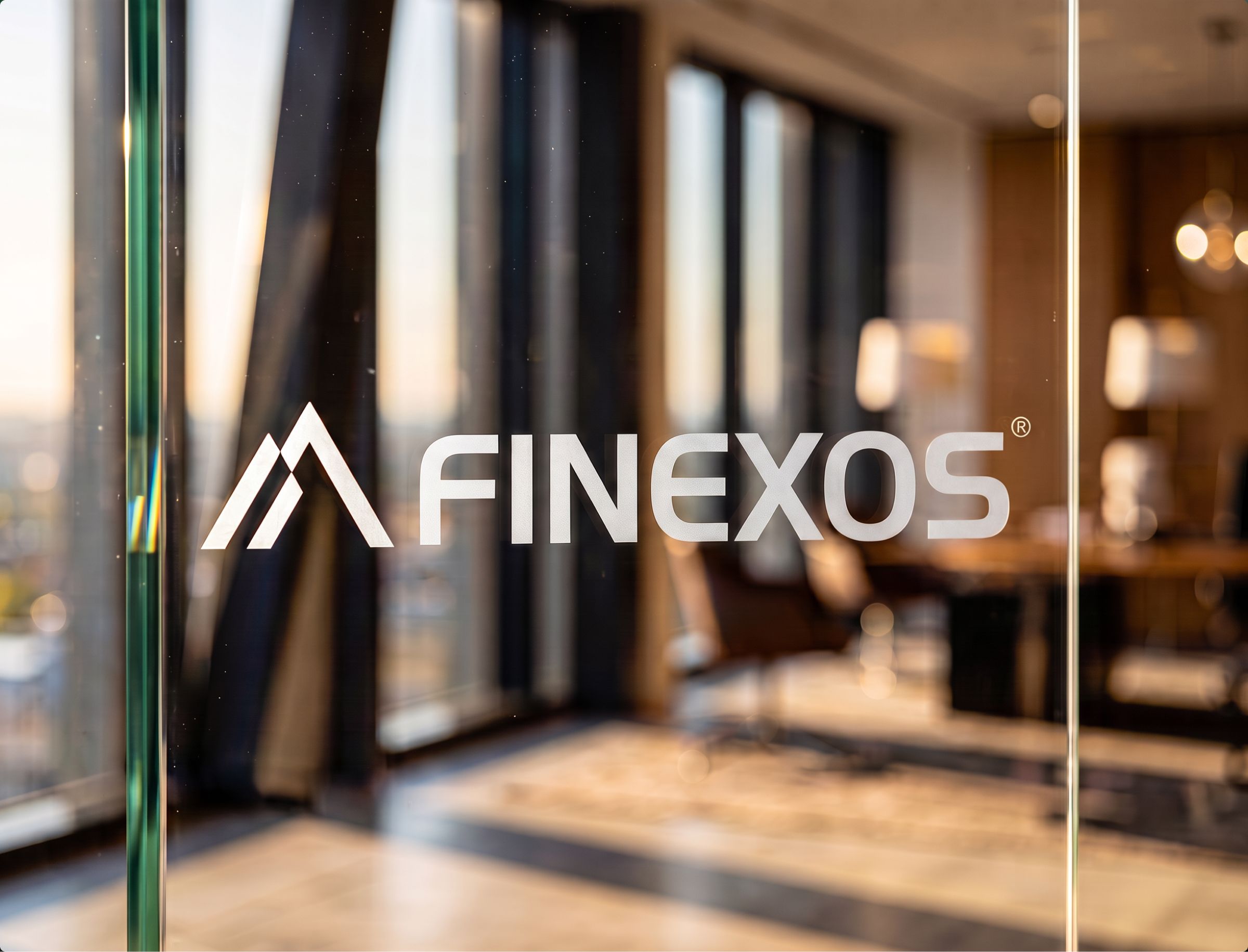 The FINEXOS logo is displayed on a glass door or window, with an interior office space visible in the blurred background.